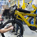 Operario con rueda de bicicleta en soporte amarillo